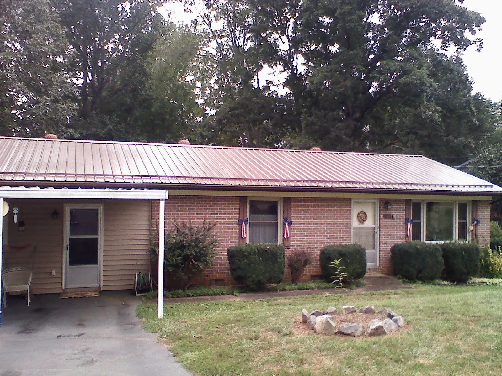 Bronze metal roof and carport on a brick ranch home — Roof Repair work by our crew in Lyndon